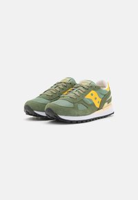 Green mesh and suede sneakers with yellow accents, black rubber sole, and distinctive design featuring a padded collar and textured surface.