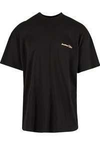 Tricou din bumbac negru cu guler rotund, mâneci scurte și un mic logo auriu pe partea stângă a pieptului. Croială lejeră, textură netedă.
