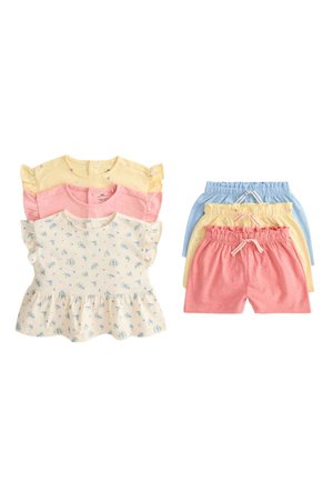 Trzy komplety bluzek i szortów dla małej dziewczynki w pastelowych kolorach: żółtym, różowym i niebieskim, z kwiatowymi nadrukami na kremowej bluzce, ułożone płasko.