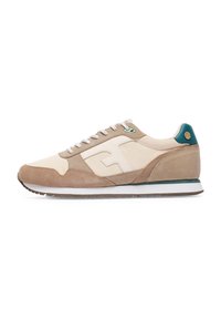 Beige- und tanfarbene Sportschuhe aus Wildleder und Textilmaterialien, mit einer weißen Zwischensohle, grünen Akzenten und einem gepolsterten Kragen.