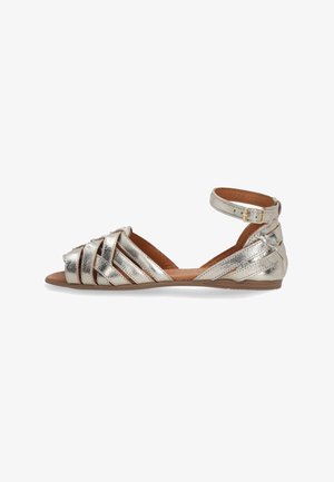 Metallic guld spænde sandal med ankelrem, flad sål, åben tå og vævet design fortil. Glat overflade og minimalistisk stil.