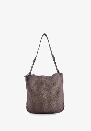 Hnědá kožená taška přes rameno s kulatým květinovým vzorem se cvočky na přední straně a nastavitelným popruhem na bílém pozadí.