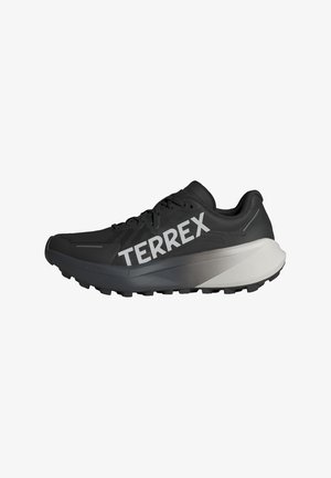 Black running shoe with a textured upper, prominent "TERREX" logo in white, tapered sole design, and a gradient gray accent on the heel.