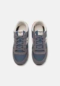 Saucony Jazz joggesko med en blå og grå overdel, stoff- og semsket lærmaterialer, rund tå og grå snøringer. Hvite detaljer og logo på tungen.