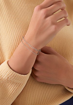 Silver chain bracelet with layered links. One chain features elongated links; the other is smaller with a more delicate design.