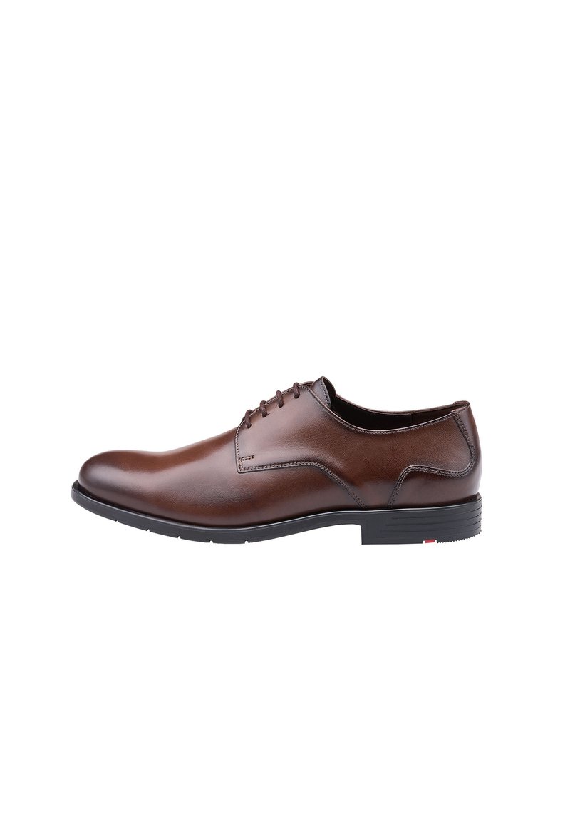 Chaussure habillée en cuir marron avec une finition lisse, bout rond et lacets. Semelle en caoutchouc noir notable avec un petit accent coloré.
