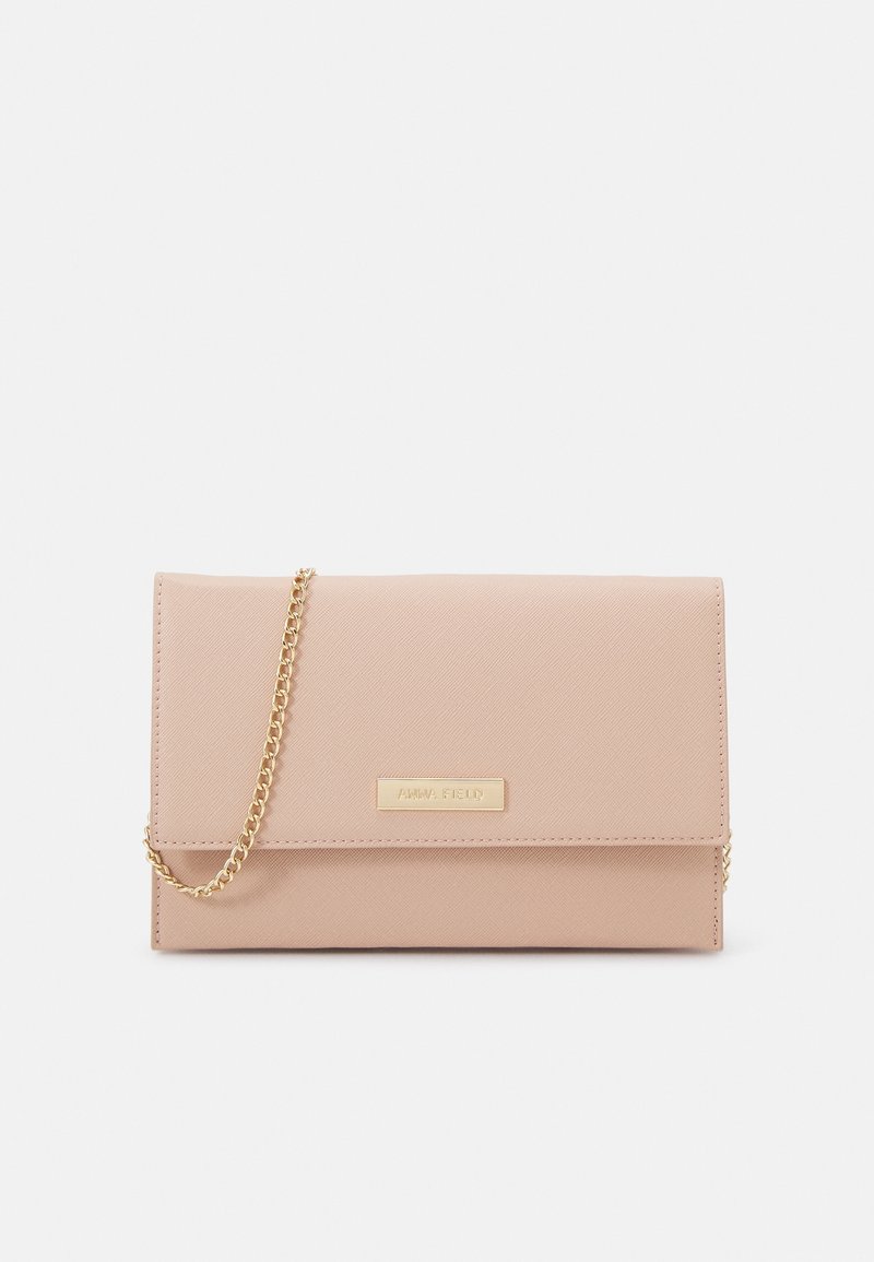 Sac bandoulière rectangulaire beige avec fermeture à rabat et bandoulière chaîne dorée, avec une petite plaque de marque dorée sur le devant.