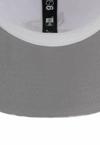 Grauer Hut mit flacher Krempe und weißen Nähten. Das Innere verfügt über ein Markenlabel und ein weiches Stofffutter. Langlebiges Textilmaterial.