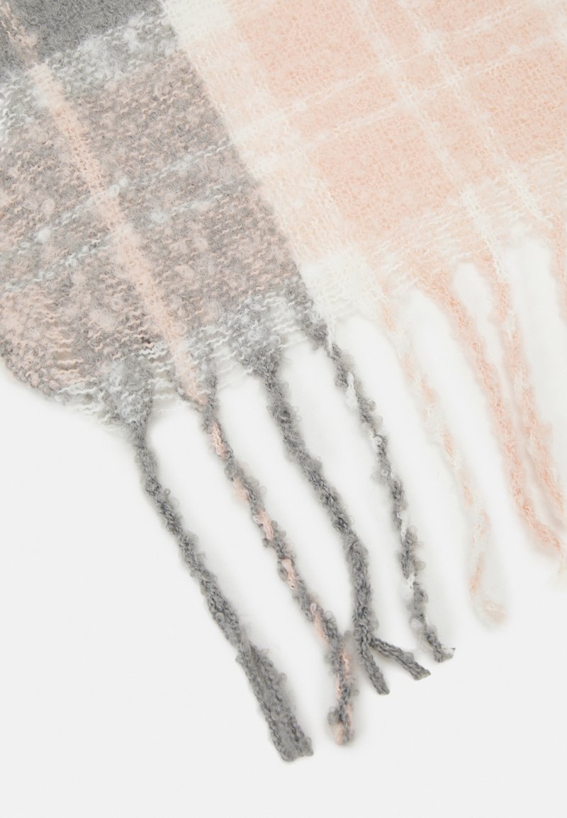 Bufanda de cuadros ligera con una textura suave y peluda en tonos durazno, gris y blanco, con bordes flecados que añaden un detalle decorativo.