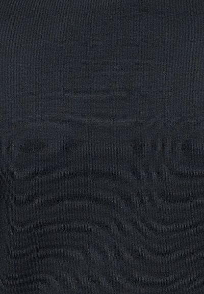 Υφή πλεκτού υφάσματος σκούρου γκρι με λεπτές, ομοιόμορφες ραφές και διακριτικές διακυμάνσεις στη σκίαση.