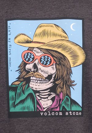 T-shirt graphique mettant en avant un squelette portant un chapeau de cowboy jaune et des lunettes de soleil roses, illustré sur un fond bleu avec du texte.