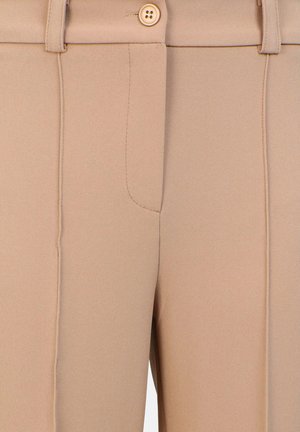 Beige mukautetut housut, joissa on sileä pinta, yksittäinen nappisulku ja kaksi sivusaumainetta ompelutiedoilla.