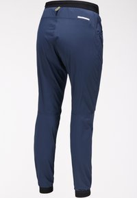 Marineblauwe sportbroek gemaakt van lichtgewicht materiaal met een zwarte elastische tailleband, boorden en een ritszak op de achterkant.