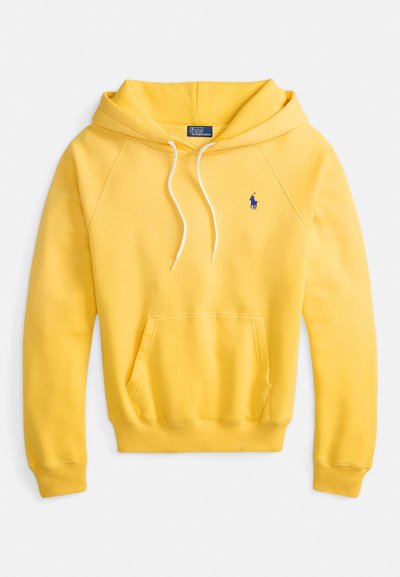 Rumena jopa iz bombaža s sprednjim žepom kenguru, vrvicami in majhnim modrim logotipom na levi strani prsi.