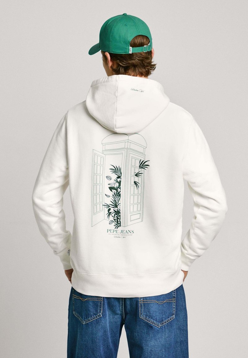 Sudadera blanca con un gráfico verde de una cabina telefónica abierta rodeada de plantas, con la marca "Pepe Jeans", combinada con jeans de mezclilla azul.