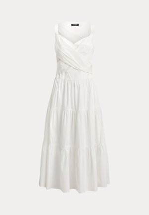 Λευκό αμάνικο μάξι φόρεμα με φούστα σε στρώσεις και μπλούζα με σταυρωτή draping σε απλό φόντο.