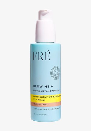 Flacone azzurro chiaro con pompa bianca; etichettato "FRÉ GLOW ME + Crema idratante colorata leggera," contiene SPF 30, destinato a tonalità di pelle media-scura.