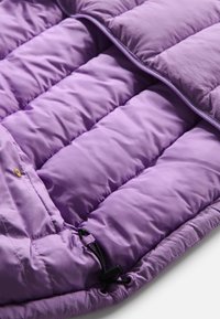 Interno di giacca a vento viola con design trapuntato e imbottito. Presenta una texture liscia, regolatore con cordino e chiusura con zip.