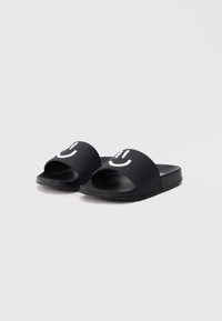 Sandale negre tip șlapi cu degete deschise, din material cauciucat, cu grafice albe cu fețe zâmbitoare pe bretele, talpă texturată pentru aderență.