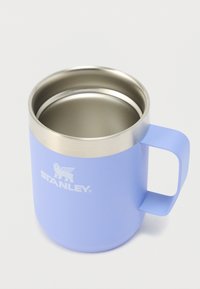 Mug en acier inoxydable de couleur violet clair, avec une surface extérieure lisse, un bord en métal et une poignée robuste. Présente un logo visible sur le côté.