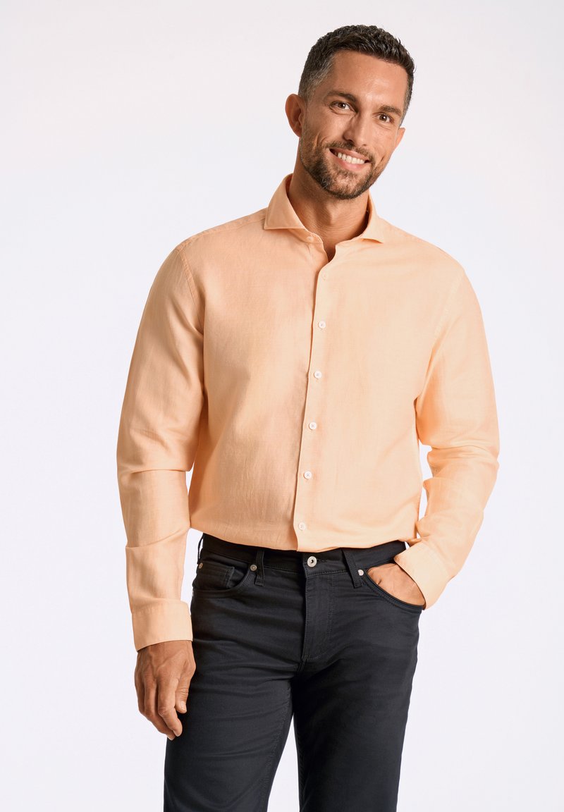 Helles orangefarbenes Langarmhemd mit Button-Down-Kragen, kombiniert mit dunkelblauen Denim-Jeans. Glatte Stoff und eine taillierte Passform.
