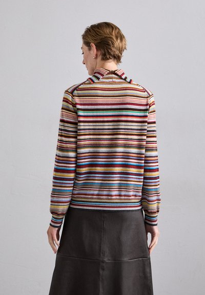 Suéter de punto a rayas con cuello, que presenta rayas multicolores en marrón, rojo, azul y amarillo, combinado con una falda de cuero oscura.