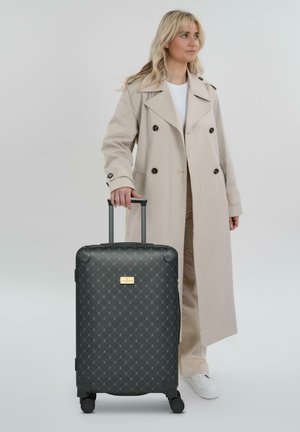 Valise rigide noire avec motif en diamant, roues robustes et une poignée rétractable. Présente une plaque logo dorée.