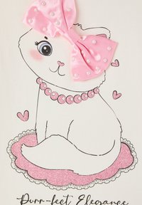 Illustrazione di un gatto in stile cartone animato con un fiocco di raso rosa, dettagli in perle e un collare glitterato rosa, seduto su un tappetino rosa con volant decorato con cuori.