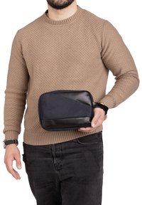Pochette da viaggio compatta in tessuto blu navy con un elegante dettaglio in pelle nera. Forma rettangolare con chiusura a zip; dotata di una maniglia corta.