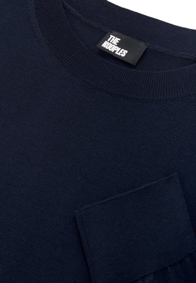 Maglietta a maniche lunghe blu navy in maglia con scollo rotondo e taschino sul petto. Texture liscia e polsini a coste, etichettata "THE KOOPLES."