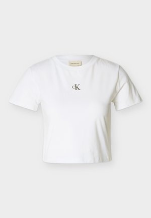Hvit kortermet croppet T-skjorte med liten svart "cK"-logo sentrert på brystet og rund hals.
