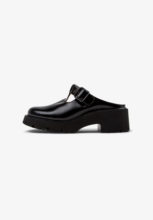 Czarne skórzane klapki typu mule na masywnym obcasie, z okrągłym noskiem, grubą podeszwą i dużym paskiem z klamrą na cholewce.