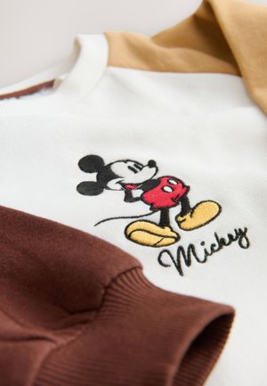 Balta sportinė palaidinė su rudos ir šviesiai rudos spalvos rankovėmis. Puošia išsiuvinėtas Miki Pelės paveikslėlis ir vardas „Mickey“ raštu kursyvu. Minkštas audinys.