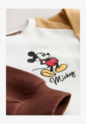 Hvid sweatshirt med brune og beige ærmer. Har broderet Mickey Mouse og navnet "Mickey" i en kursiv skrifttype. Blød tekstur.