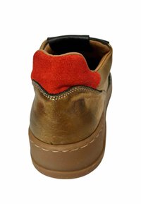 Bronzefarbener Sneaker mit einem strukturierten Lederoberteil und einem roten Wildlederakzent an der Ferse. Verfügt über eine abgerundete Form und eine beige Gummisohle.