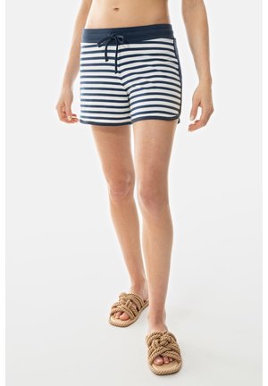 Gestreepte marineblauwe en witte zwembroek met een trekkoord in de taille. Zachte, lichte stof. Gecombineerd met gestructureerde beige sandalen.