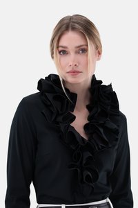 Black blouse with a prominent ruffled neckline, soft fabric, long sleeves, and a fitted design, complemented by a slim white belt.