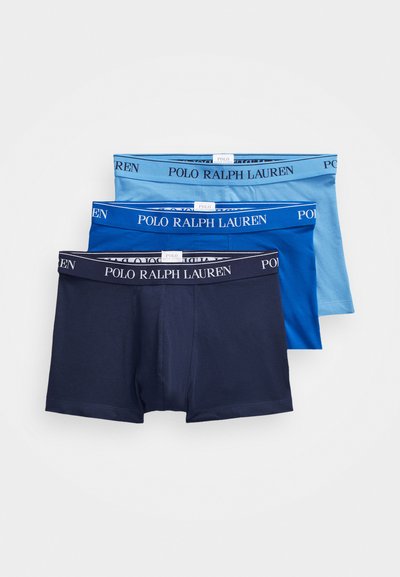 Trois paires de boxers pour hommes de teintes bleues variées : bleu marine foncé, bleu moyen et bleu clair, chacun avec une ceinture élastique de marque.