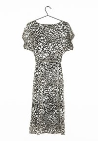 Czarna i biała sukienka w kwiatowy wzór, wykonana z lekkiej tkaniny, o luźnym kroju, z krótkimi rękawami i paskiem w talii.