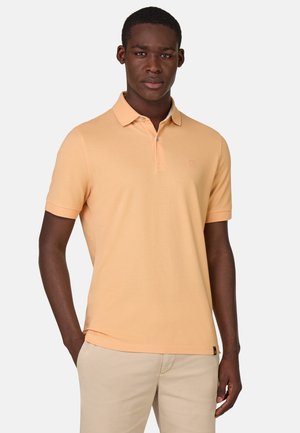 Polo in color pesca chiaro, maniche corte, design con colletto, realizzato in cotone, con un logo discreto sul petto e una vestibilità comoda.