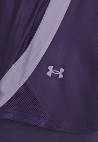 Top sportivo viola caratterizzato da un tessuto testurizzato, bordi di un viola chiaro in contrasto e dettagli in rete. Include un piccolo logo sul lato.