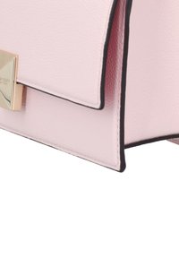 Pink leather handbag with a structured shape, black trim, and a metal clasp accent. Textured surface and clean stitching detail.