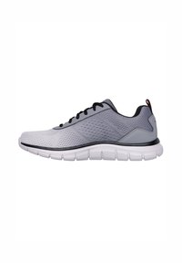 Scarpa sportiva grigia con una tomaia in rete, lacci neri e una suola bianca imbottita caratterizzata da un design testurizzato e scanalature flessibili.