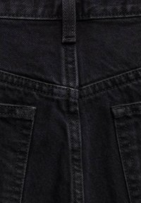 Črne kavbojke iz denima z običajnim pasom, dvema zadnjima žepoma in kontrastnimi šivi. Tkanina ima nežen teksturiran videz.