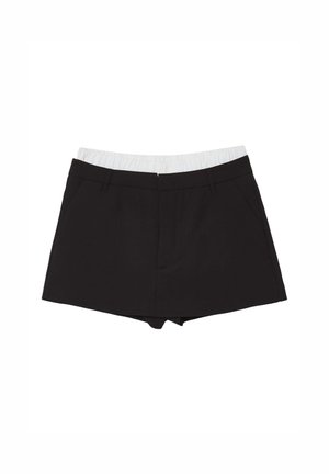 Pantaloni shorts neri con una cintura elastica bianca, dotati di due tasche laterali e un design sartoriale. Realizzati in un tessuto liscio.