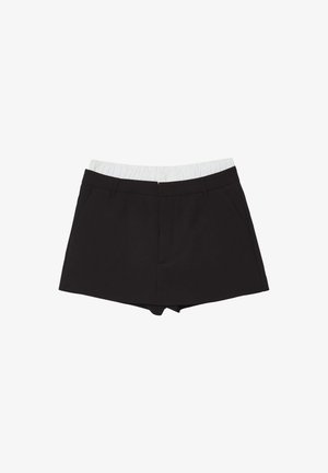 Pantaloni shorts neri con una cintura elastica bianca, dotati di due tasche laterali e un design sartoriale. Realizzati in un tessuto liscio.