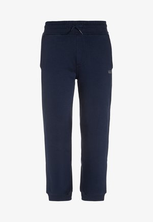 Granatowe spodnie dresowe Vans z elastycznym pasem i sznurkiem, ściągaczami oraz subtelnym logo Vans na górnej części uda.