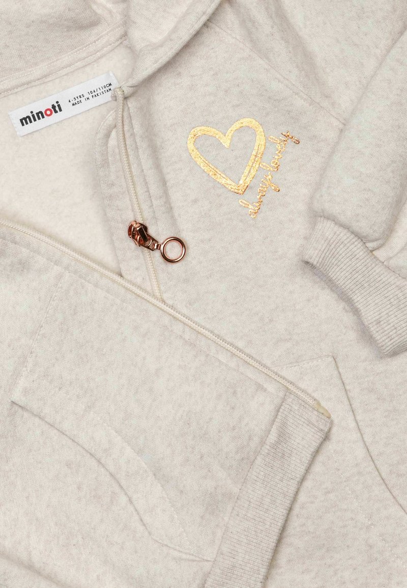 Kremowa bluza z zamkiem błyskawicznym, z teksturowanej tkaniny, z złotym sercem i haftem "zawsze urocza", oraz z przednią kieszenią.