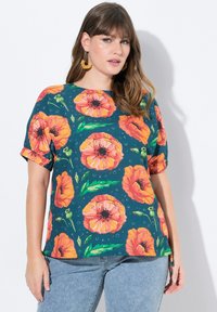 Kortærmet bluse i mørk teal med stort print af orange valmueblomster, grønne blade og en afslappet pasform. Blød tekstur med dekorative manchet detaljer.
