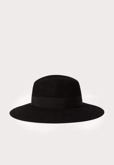 Chapeau en feutre noir avec un large bord et un bandeau en ruban noir texturé autour de la base de la couronne. Surface lisse, forme arrondie.